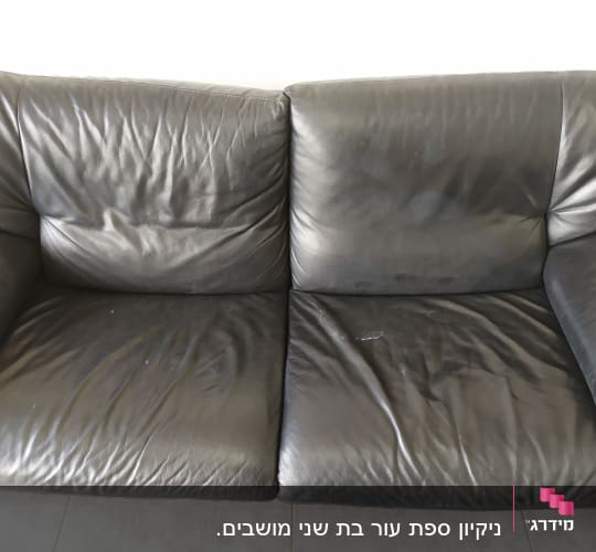 ספה עור שחורה עם קמטים וכתמים קלים